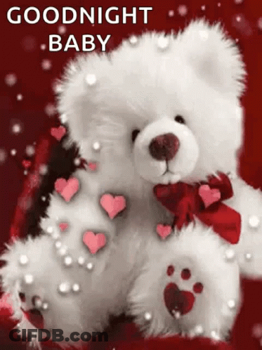 White Teddy Bear With Red Bow And Hearts On Paws On Red Blanket GIF