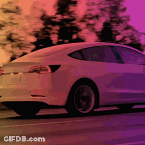 White Tesla Model 3 Driving Down Road GIF