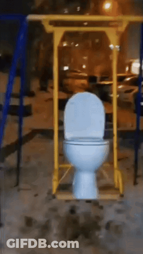 White Toilet Hanging From Yellow Pole In Playground GIF