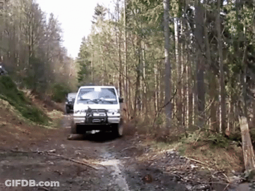 White Truck Driving Down Dirt Road GIF