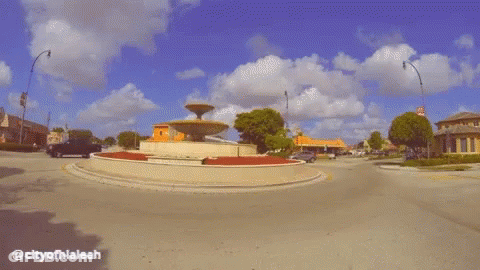 White Truck Driving Past Fountain City Of Hialeah GIF