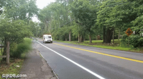 White Van Driving Down Road With Trees GIF