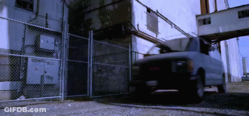 White Van Parked In Front Of Chain Link Fence GIF