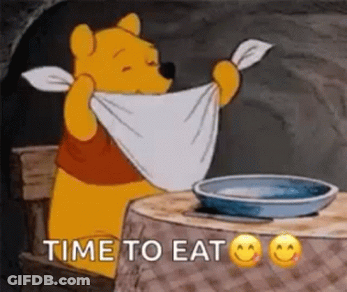 Winnie The Pooh Is Sitting At A Table Holding A Towel Around His Neck And Says `` Time To Eat '' . GIF