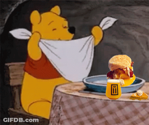 Winnie The Pooh Is Sitting At A Table With A Plate Of Food GIF