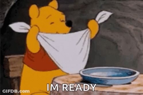 Winnie The Pooh Is Sitting At A Table With A Towel Around His Neck And A Bowl Of Water . GIF