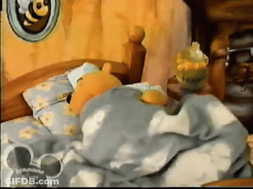 Winnie The Pooh Is Sleeping In A Bed With A Mickey Mouse Ear GIF