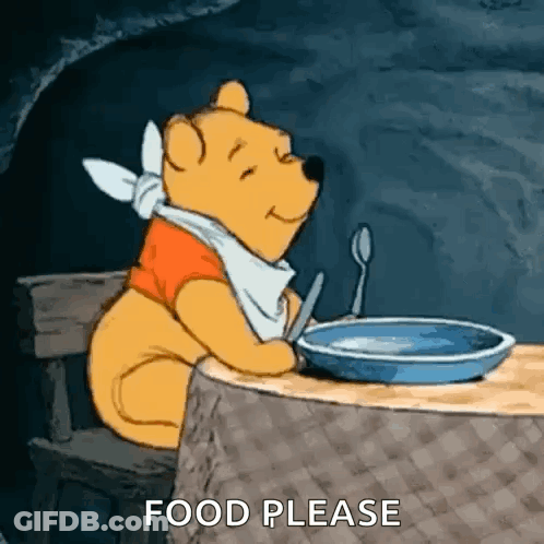Winnie The Pooh Sitting At Table With Spoon In Mouth GIF