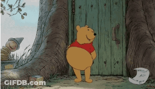 Winnie The Pooh Standing In Front Of Wooden Door GIF