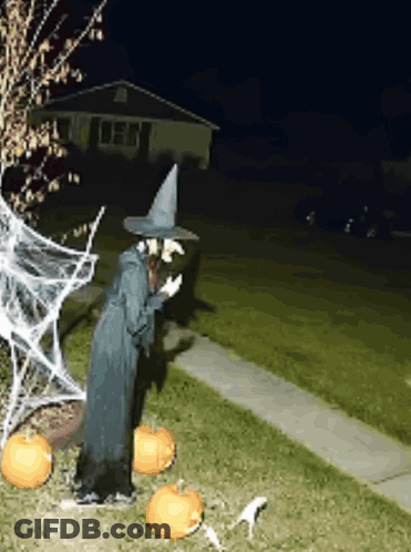 Witch Statue At House With Pumpkins And Spider Web GIF