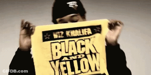 Wiz Khalifa Holding Black And Yellow Sign GIF