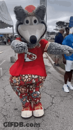 Wolf Mascot In Red Shirt And Floral Pants Standing On Street GIF