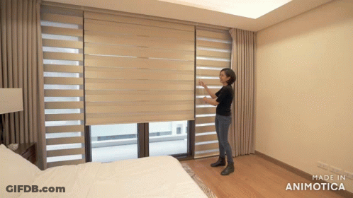 Woman Adjusting Blind In Bedroom GIF