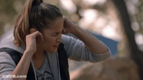 Woman Adjusting Ear Buds In Bear T-Shirt GIF