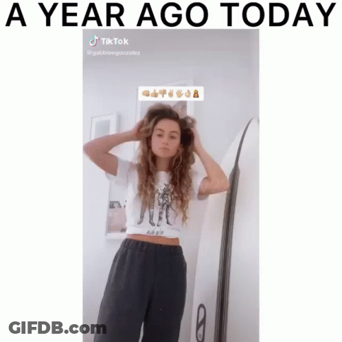 Woman Adjusting Hair Next To Surfboard A Year Ago Today GIF