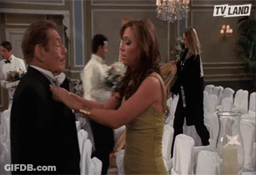 Woman Adjusting Man's Tie In Front Of TV Land Ad GIF