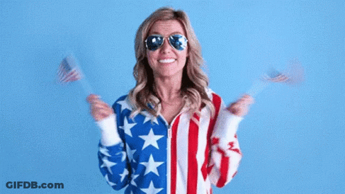 Woman American Flag Jacket Sunglasses Holding Two American Flags GIF