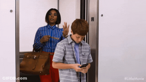 Woman And Boy In Elevator Boy Looking At Phone GIF