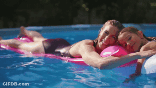Woman And Child Laying On Rafts In Pool GIF