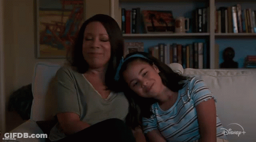 Woman And Girl Sitting On Couch Watching Disney+ Show GIF