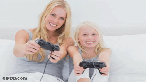 Woman And Little Girl Playing Video Game On Bed GIF