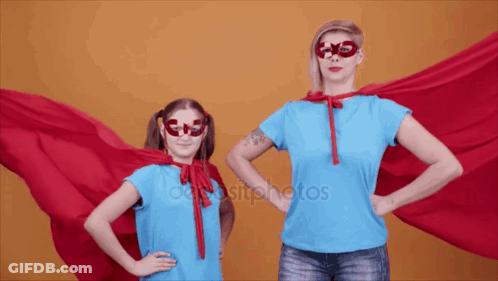 Woman And Little Girl Superhero Costumes Hands On Hips GIF