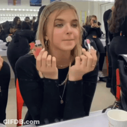 Woman Applying Lipstick In Front Of Mirror GIF
