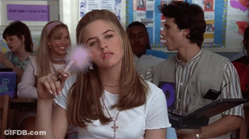 Woman Applying Makeup In Classroom While Man Eating Candy Bar GIF