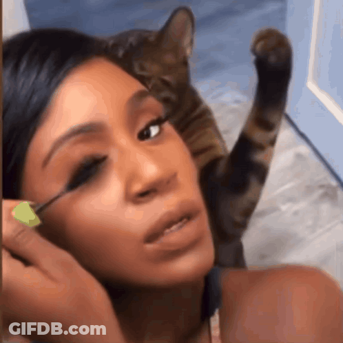 Woman Applying Mascara While Cat Watches GIF