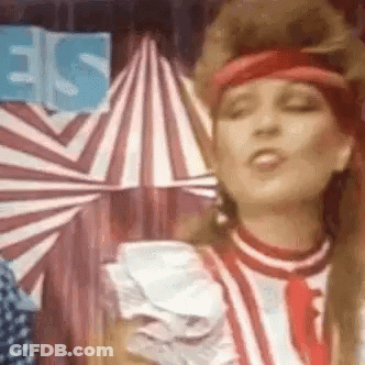 Woman At Circus Tent With Red Headband And Tie GIF