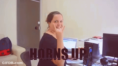 Woman At Computer With Horns Up On Screen GIF