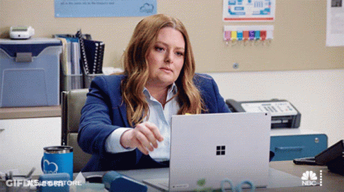 Woman At Desk With Laptop And Superstore Mug GIF