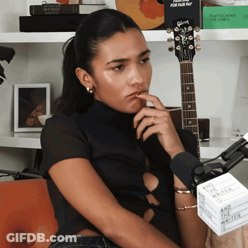 Woman At Microphone With Sign And The Writer Is GIF