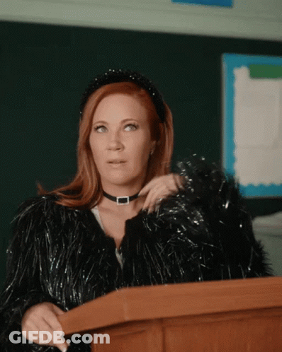 Woman At Podium In Choker And Fur Coat GIF