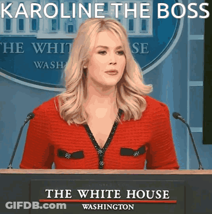 Woman At Podium With Karoline The Boss Sign GIF