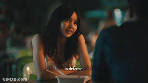 Woman At Table Saying In Defense GIF