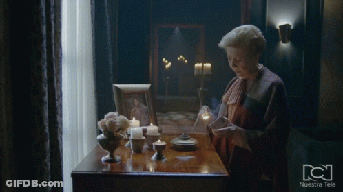 Woman At Table With Candles And Nuestra Tele Frame GIF