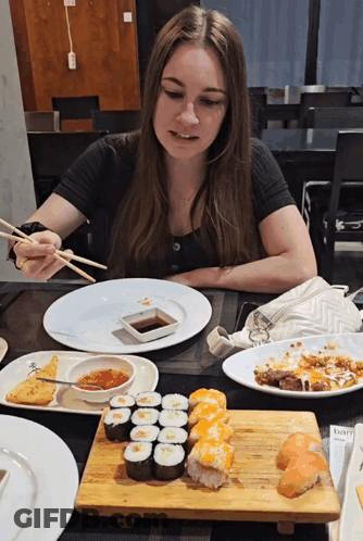 Woman At Table With Chopsticks And Sushi GIF