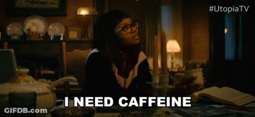 Woman At Table With Coffee Saying I Need Caffeine GIF