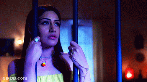 Woman Behind Bars With Rainbow Necklace GIF