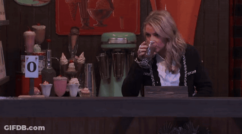 Woman Behind Counter With Sign Saying O GIF
