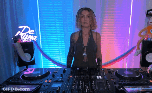 Woman Behind DJ Mixer In Front Of De Luna Neon Sign GIF