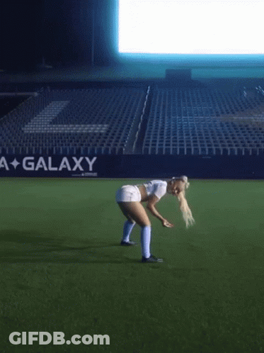 Woman Bending Over On Soccer Field With Galaxy Sign GIF