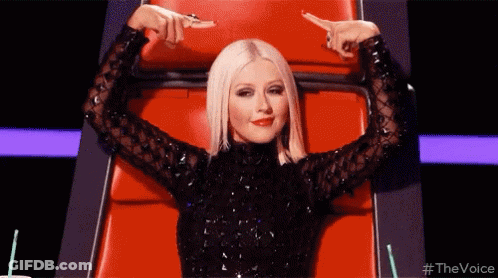 Woman Black Dress Pointing At Herself Red Chair GIF