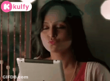 Woman Blowing Kiss Looking At Tablet GIF