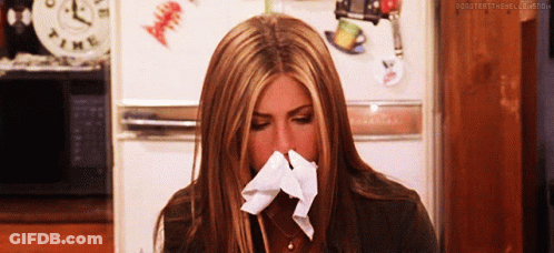 Woman Blowing Nose In Front Of Clock Saying Time GIF