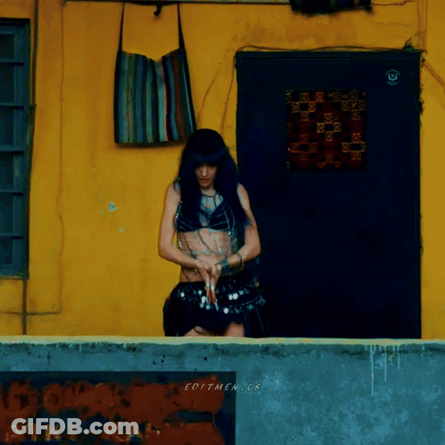 Woman By Yellow Wall With Editmen.cr Sign GIF