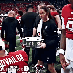 Woman Carrying Tray Of Cans On Football Field GIF