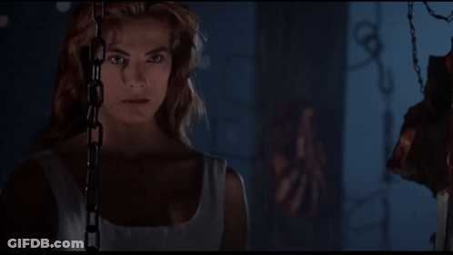 Woman Chained To Wall Looking At Camera GIF