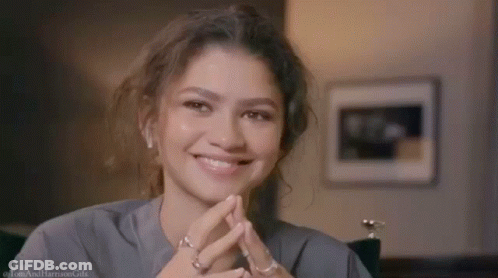 Woman Close Up Smiling With Hands Folded GIF